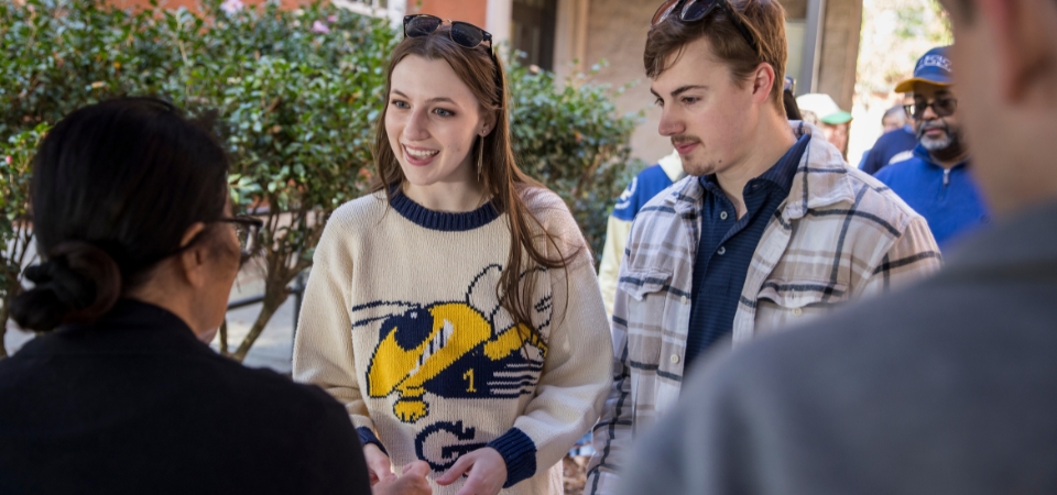 Group of students and alumni chatting at the annual IAC Homecoming tailgate.