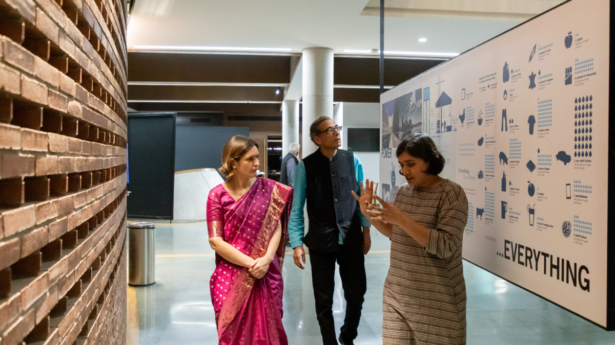 Jahnavi explaining an exhibition to two visitors at the gallery 